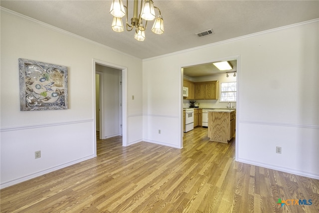 interior space featuring visible vents, baseboards, a chandelier, crown molding, and light wood finished floors