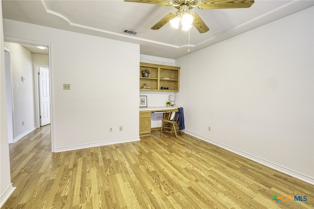 unfurnished office featuring ceiling fan, light wood finished floors, built in study area, and visible vents