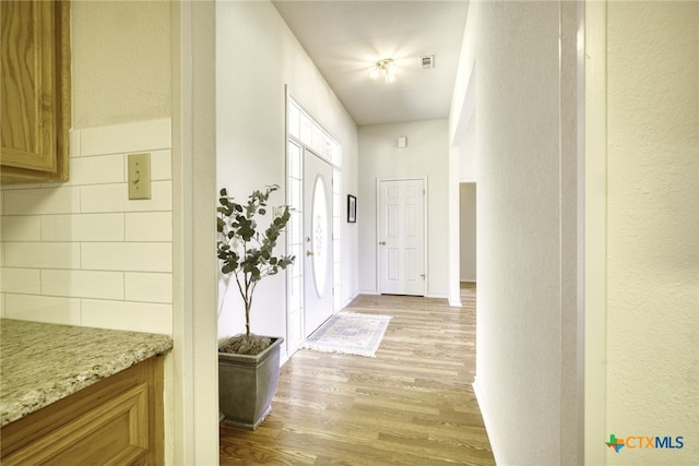 interior space with baseboards and light wood finished floors