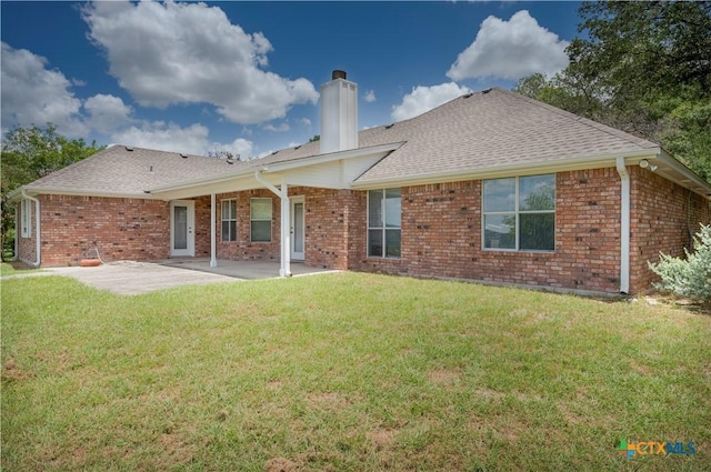 back of house featuring a patio, brick siding, and a lawn