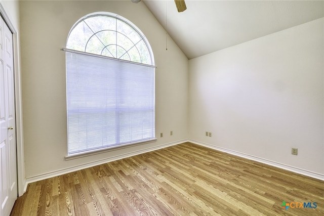 spare room with lofted ceiling, ceiling fan, baseboards, and wood finished floors