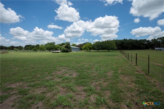 view of yard with a rural view and fence
