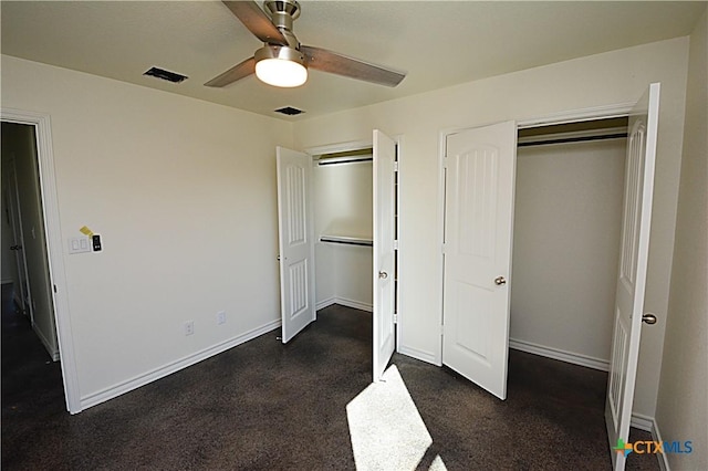 unfurnished bedroom featuring dark colored carpet, a closet, and ceiling fan