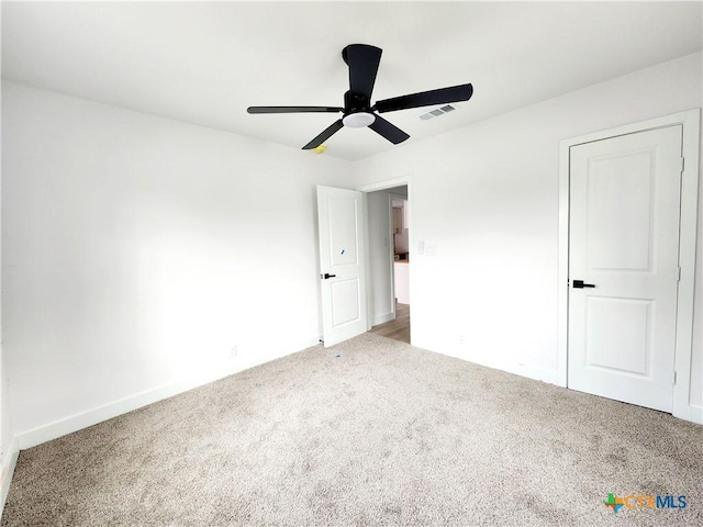 unfurnished bedroom with carpet floors, ceiling fan, and visible vents