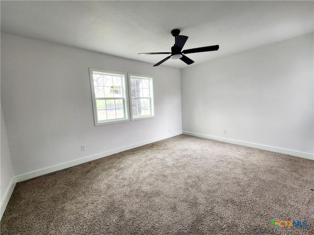 carpeted spare room with baseboards and a ceiling fan