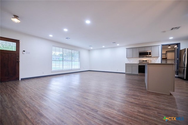 2405 Redwing Dr, Temple, TX 76502 - unfurnished living room with dark wood-type flooring and recessed lighting