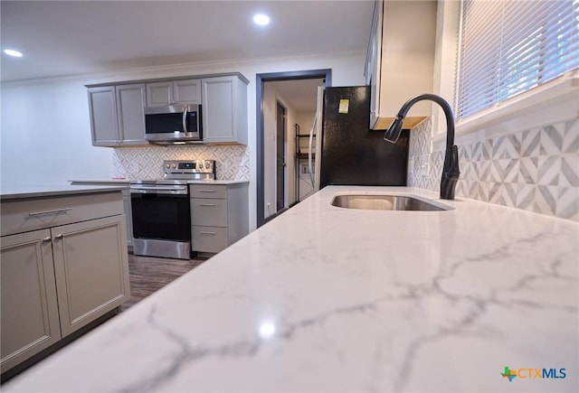2405 Redwing Dr, Temple, TX 76502 - kitchen with appliances with stainless steel finishes, gray cabinetry, crown molding, decorative backsplash, and recessed lighting