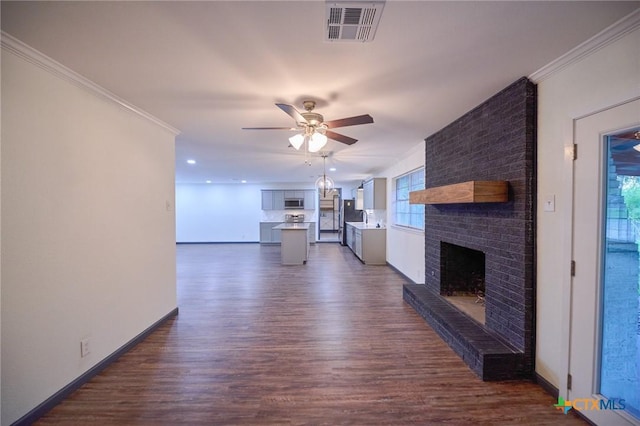 2405 Redwing Dr, Temple, TX 76502 - unfurnished living room with dark wood-style flooring, ceiling fan, a brick fireplace, ornamental molding, and recessed lighting