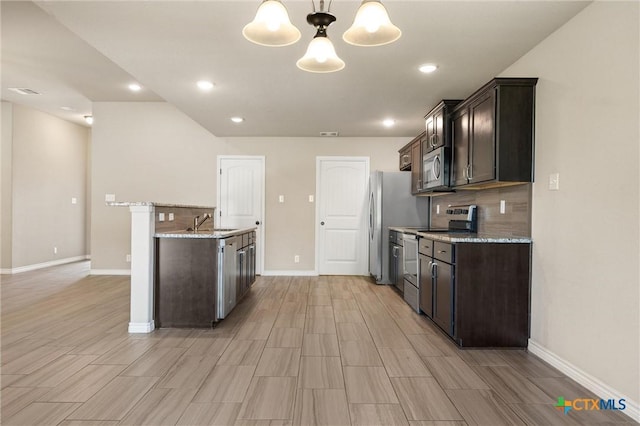 716 Kendra Dr, Temple, TX 76502 - kitchen featuring stainless steel appliances, dark brown cabinets, tasteful backsplash, light stone countertops, and recessed lighting