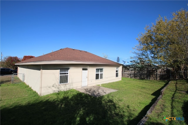 back of house with a yard and a patio