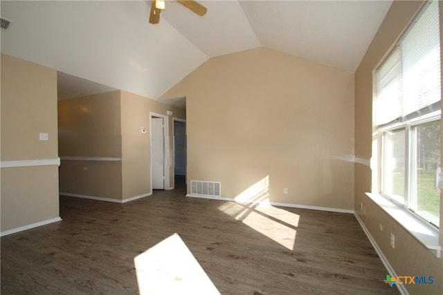 empty room featuring dark hardwood / wood-style flooring, vaulted ceiling, and ceiling fan