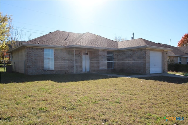 ranch-style house with a garage and a front lawn