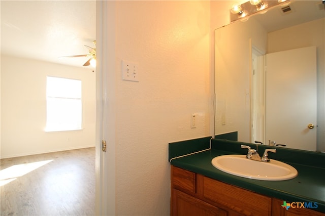 bathroom with hardwood / wood-style floors, vanity, and ceiling fan