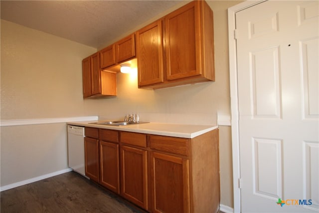 kitchen featuring dishwasher, dark wood-type flooring, and sink