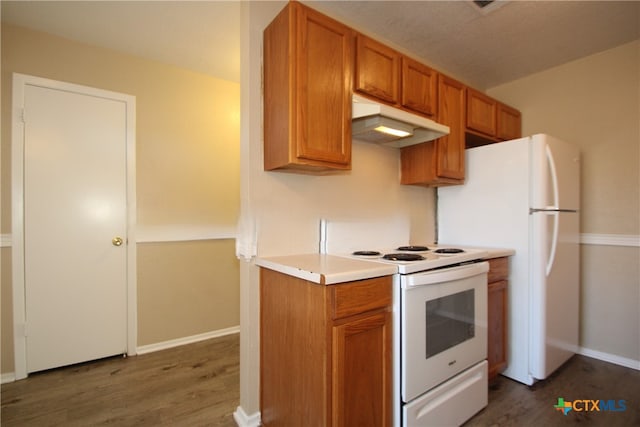 kitchen with dark hardwood / wood-style flooring and white appliances