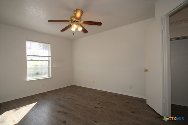 unfurnished bedroom with dark hardwood / wood-style flooring, a closet, and ceiling fan