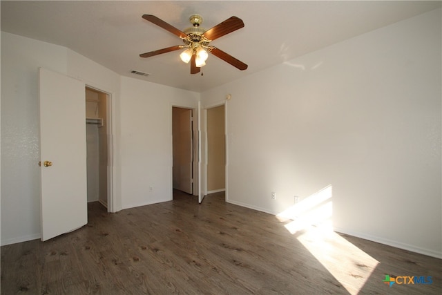 unfurnished bedroom featuring ceiling fan, a closet, and dark wood-type flooring