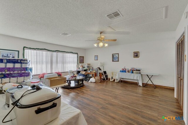 12204 Mustang Dr, Buda, TX 78610 - living area with a textured ceiling, ceiling fan, visible vents, and wood finished floors