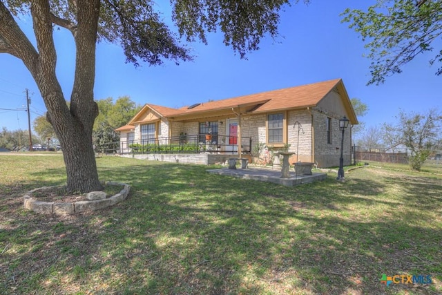 12204 Mustang Dr, Buda, TX 78610 - view of front of house with a front yard, fence, and stone siding