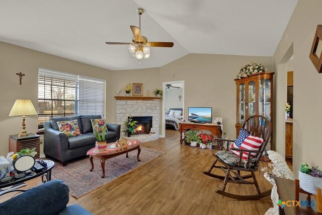 12204 Mustang Dr, Buda, TX 78610 - living area with lofted ceiling, wood finished floors, a ceiling fan, and a brick fireplace