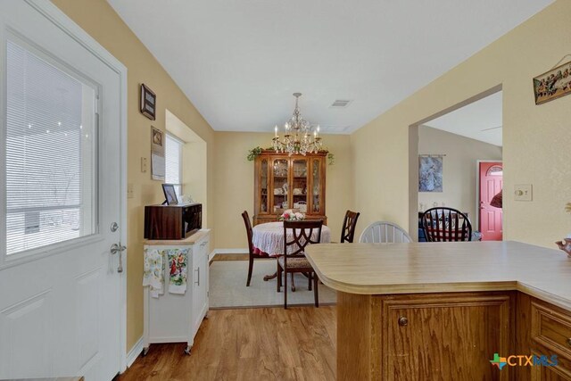 12204 Mustang Dr, Buda, TX 78610 - dining space featuring light wood-style flooring, visible vents, and a chandelier
