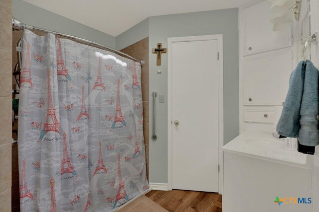 12204 Mustang Dr, Buda, TX 78610 - full bath featuring wood finished floors, a shower with shower curtain, and vanity