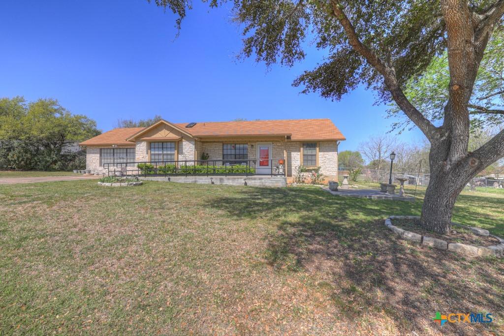 12204 Mustang Dr, Buda, TX 78610 - ranch-style home with fence and a front lawn