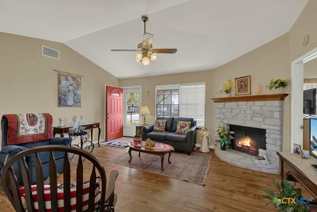 12204 Mustang Dr, Buda, TX 78610 - living area with lofted ceiling, visible vents, a ceiling fan, a stone fireplace, and wood finished floors