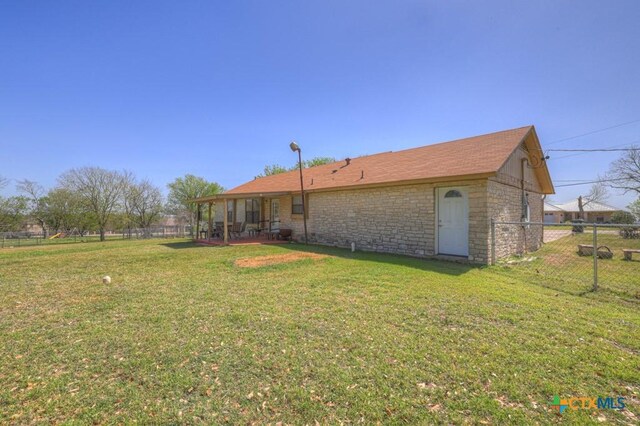12204 Mustang Dr, Buda, TX 78610 - back of property with a lawn, fence, and stone siding
