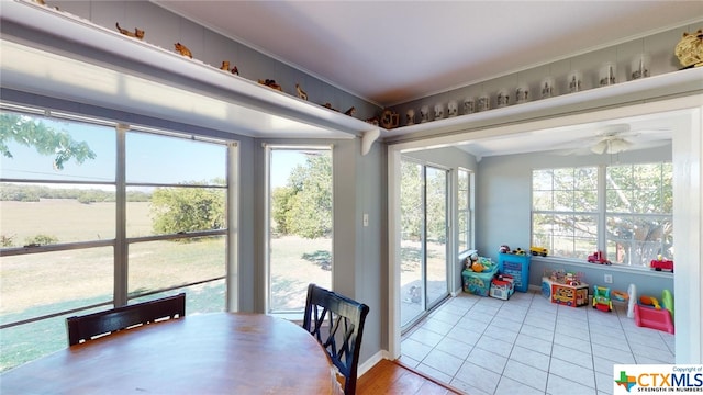 sunroom / solarium with ceiling fan and a healthy amount of sunlight