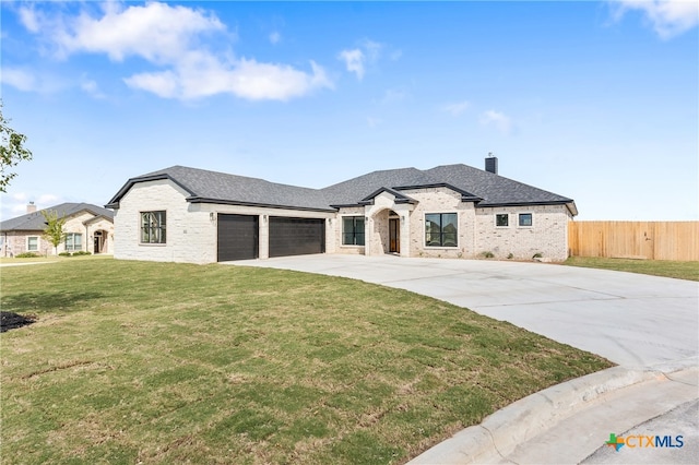 french country inspired facade with a front yard and a garage