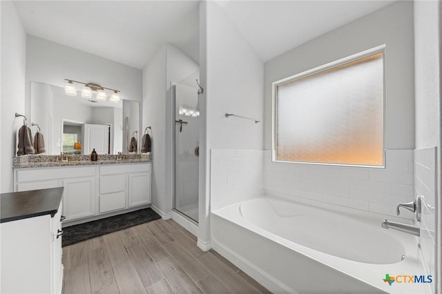 5702 Fenton Ln, Belton, TX 76513 - bathroom featuring vanity, a shower stall, a garden tub, wood finished floors, and baseboards