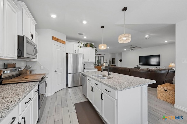 5702 Fenton Ln, Belton, TX 76513 - kitchen featuring stainless steel appliances, a sink, a ceiling fan, light wood-type flooring, and white cabinetry