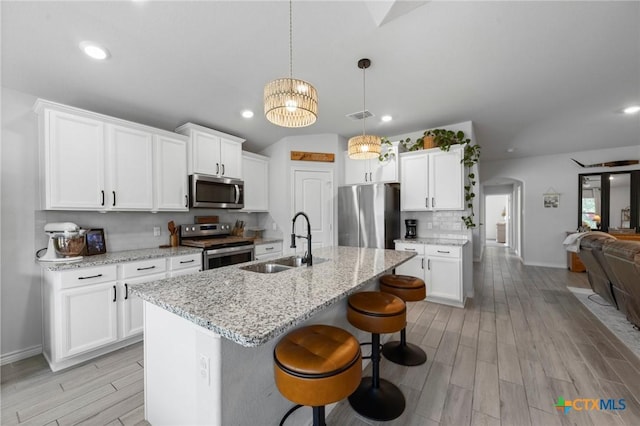 5702 Fenton Ln, Belton, TX 76513 - kitchen with appliances with stainless steel finishes, a sink, light wood-style floors, a kitchen breakfast bar, and baseboards