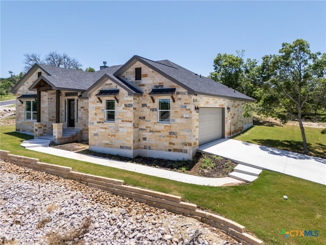 101 Dawna Len Dr, Burnet, TX 78611 - view of front of house featuring stone siding, concrete driveway, a garage, a front lawn, and a shingled roof