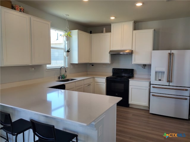 kitchen featuring white refrigerator with ice dispenser, white cabinetry, hanging light fixtures, sink, and black / electric stove