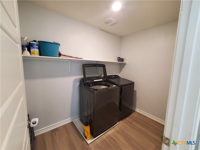 laundry room featuring hardwood / wood-style floors and washer and dryer