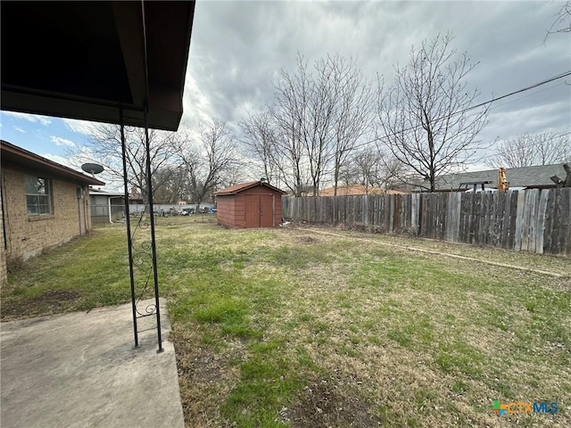 view of yard featuring an outbuilding, fence, and a shed