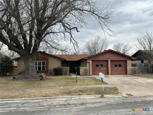 view of front of home featuring a garage, brick siding, and driveway