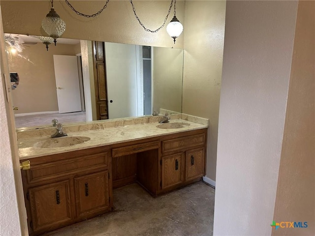 bathroom with double vanity, unfinished concrete floors, a textured wall, and a sink