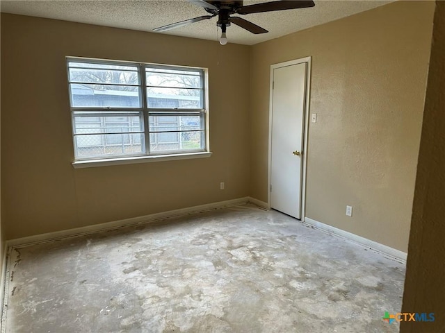 unfurnished room with ceiling fan, a textured ceiling, concrete flooring, and baseboards