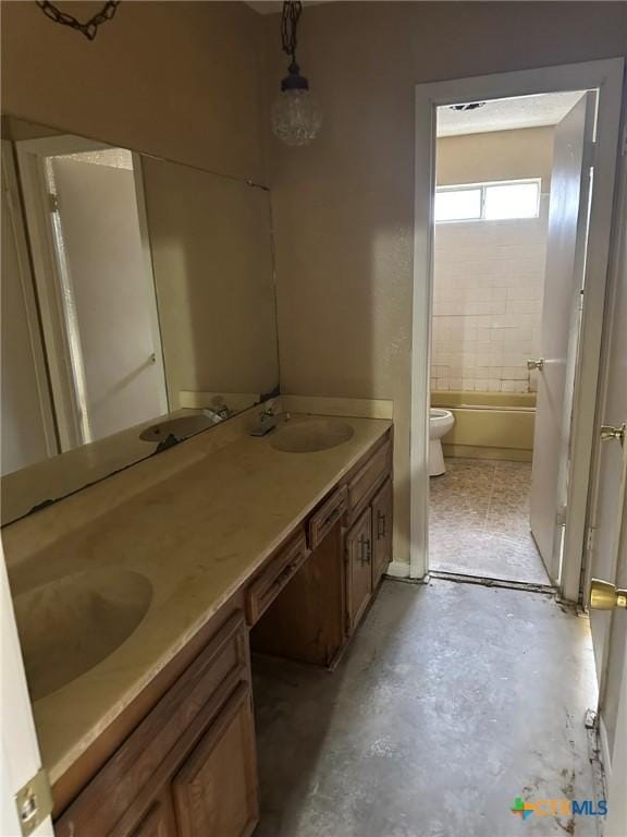 full bathroom with double vanity, toilet, and a sink