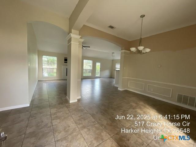 517 Crazy Horse Cir, Harker Heights, TX 76548 - unfurnished dining area featuring ornate columns, arched walkways, a chandelier, and tile patterned flooring