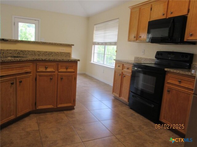 517 Crazy Horse Cir, Harker Heights, TX 76548 - kitchen featuring black appliances, plenty of natural light, tile patterned flooring, light stone counters, and vaulted ceiling