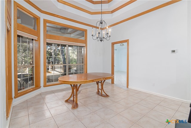 dining room featuring a tray ceiling, a chandelier, light tile patterned floors, and ornamental molding