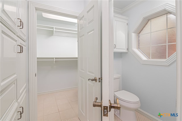 bathroom with tile patterned flooring, toilet, and crown molding