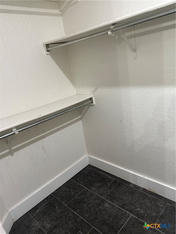 spacious closet featuring dark tile patterned floors