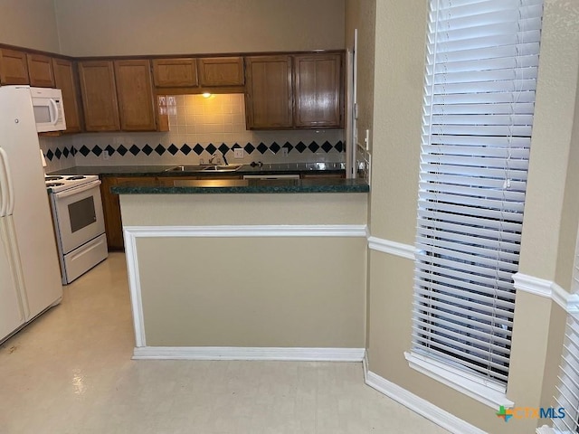 4110 Windwood Dr, Killeen, TX 76542 - kitchen featuring white appliances, dark countertops, and tasteful backsplash