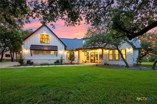 back house at dusk with a lawn