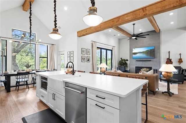 kitchen featuring white cabinetry, plenty of natural light, decorative light fixtures, and a tile fireplace